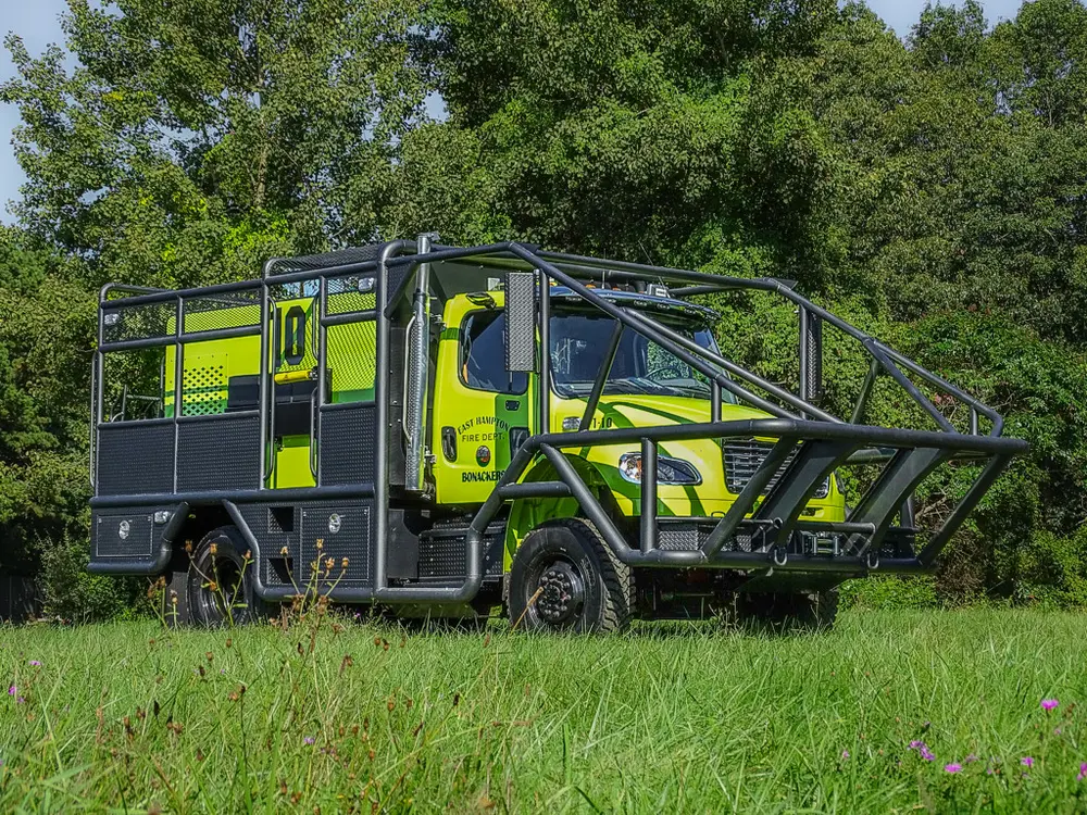Front three-quarter view of lime-yellow brush truck with protective cage.