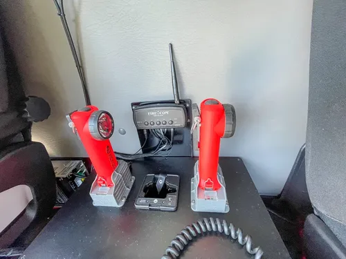 Red handheld controls and charging cradles mounted on panel.