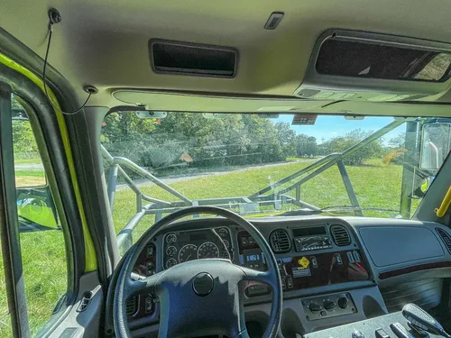 Wide dashboard view from center showing windshield and controls.