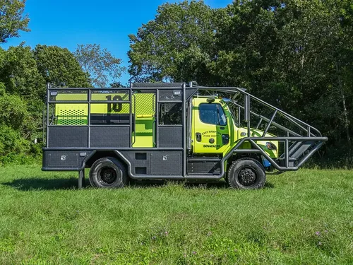 Driver-side profile of brush truck parked on grass.
