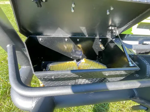 Open front bumper compartment showing metal interior paneling.