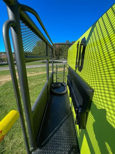 Narrow walkway channel between cage rail and body panel.