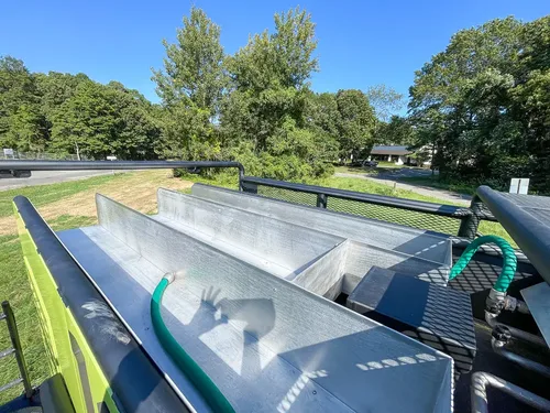 Top surface of water tank with tied hose and handle.