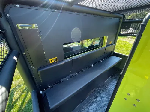 Open upper side shelf near tank with long tools stored.