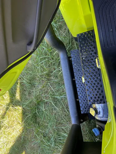 Close-up of perforated side step below door.