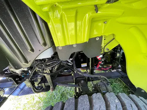 Rear axle and suspension close-up under body panel.