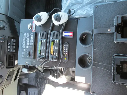 Exterior view of small fire truck showing cab, body compartments, and wheel/tire area.