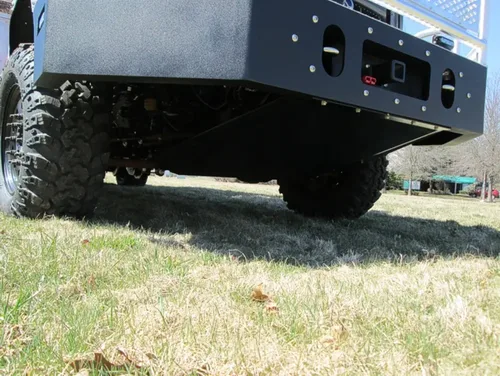 Exterior view of small fire truck showing cab, body compartments, and wheel/tire area.