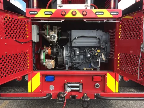 Exterior view of small fire truck showing cab, body compartments, and wheel/tire area.