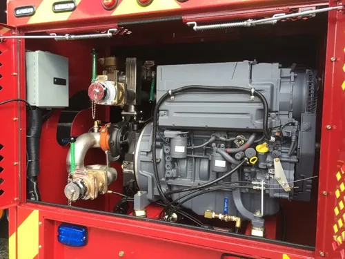 Exterior view of small fire truck showing cab, body compartments, and wheel/tire area.
