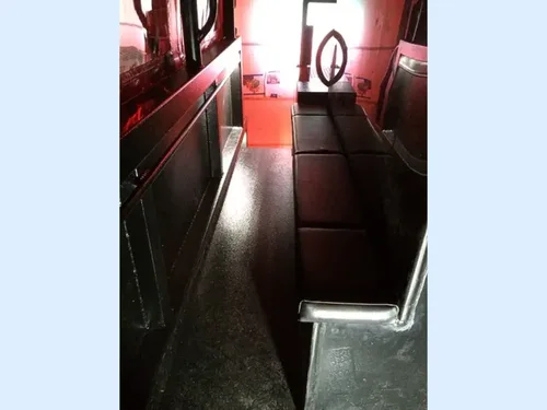 Exterior view of small fire truck showing cab, body compartments, and wheel/tire area.