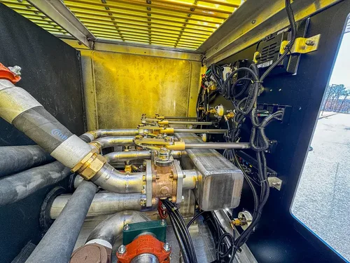Wide pump compartment view with multiple hoses and control valves.