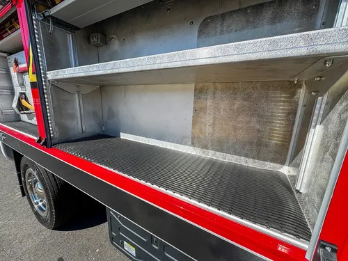 Side compartment close-up with fold-down tray and empty bay.