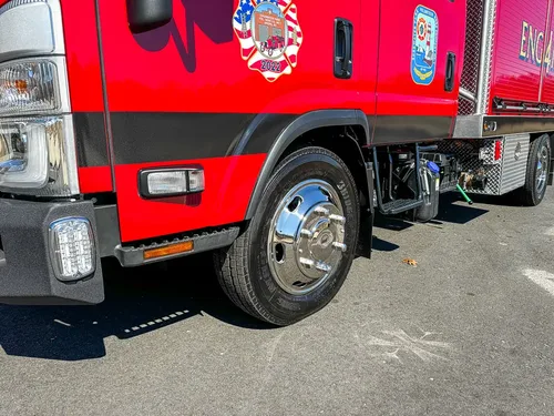 Front-left wheel and lower cab step area close-up.