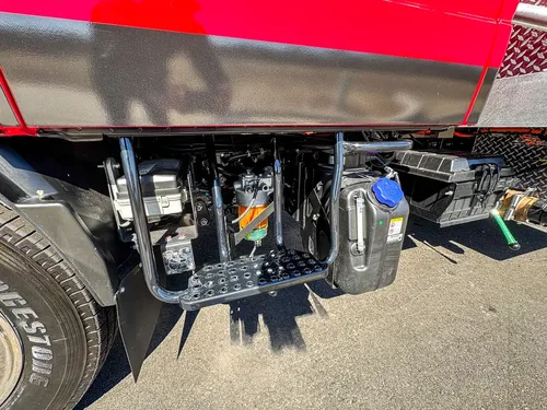 Lower chassis and pump plumbing close-up behind the cab.