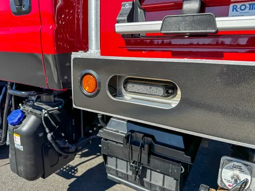 Lower side body close-up with marker light and underbody components.