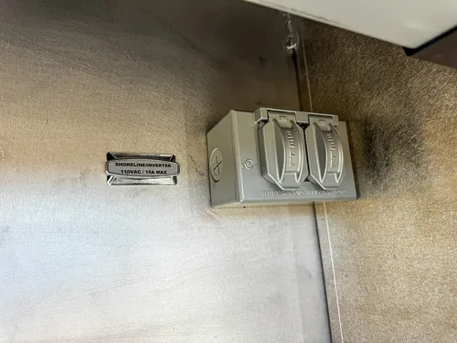 Compartment wall close-up with mounted electrical outlet box.