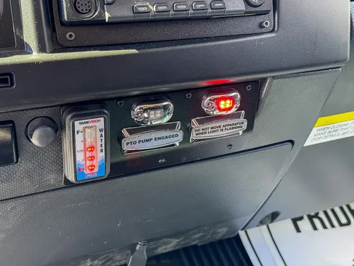 Lower dashboard close-up with switches, indicator lights, and power ports.