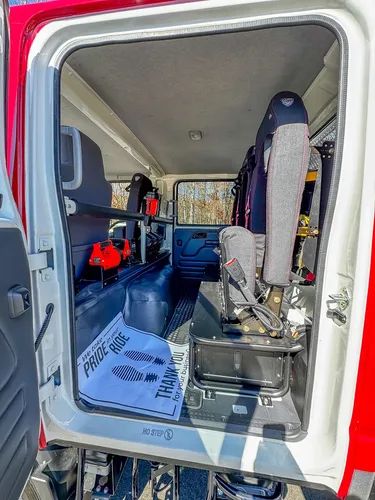 Rear cabin side view with fold-down seating and floor mat.