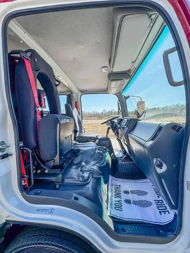 Front cabin viewed from passenger side with steering wheel and console.
