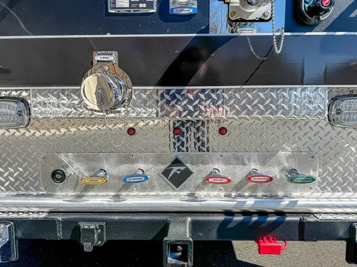 Diamond-plate rear step close-up with labeled connection ports.