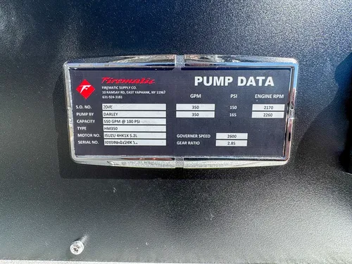 Close-up of pump data placard mounted on a dark panel.