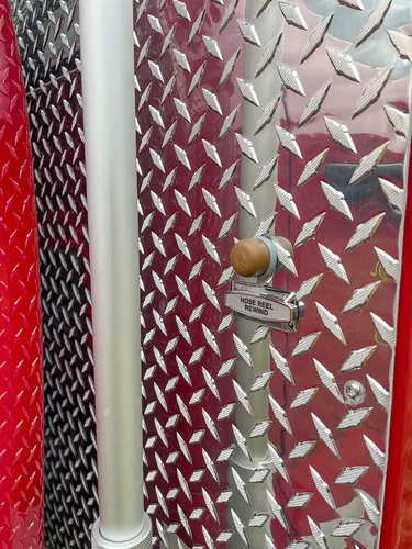 Close-up of labeled side switch and knob on diamond plate.