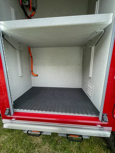 Empty lower compartment with black rubber floor mat.