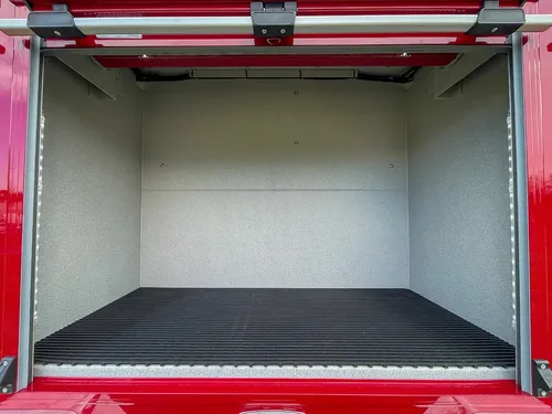 Large open rear side compartment with black floor mat.