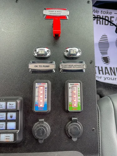 Cab switch panel with pump activation lights and level gauges.