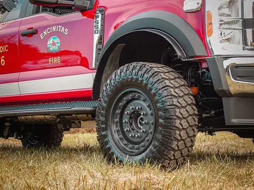 Driver-side front quarter close-up with wheel and door graphics.