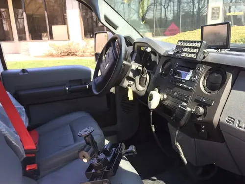 Exterior view of small fire truck showing cab, body compartments, and wheel/tire area.