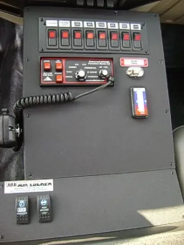 Exterior view of small fire truck showing cab, body compartments, and wheel/tire area.