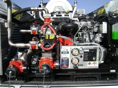 Exterior view of small fire truck showing cab, body compartments, and wheel/tire area.