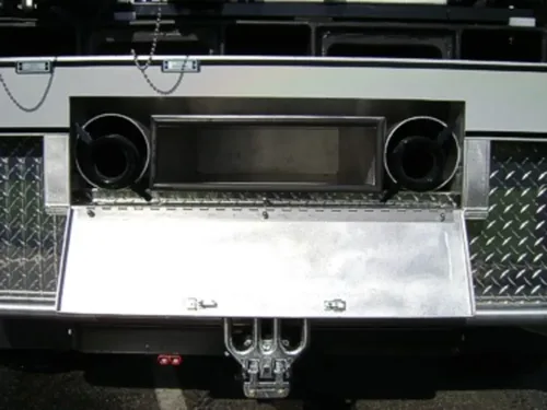 Exterior view of small fire truck showing cab, body compartments, and wheel/tire area.