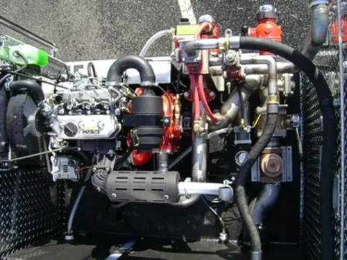 Exterior view of small fire truck showing cab, body compartments, and wheel/tire area.