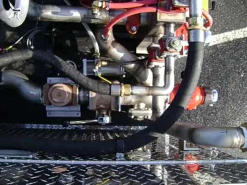 Exterior view of small fire truck showing cab, body compartments, and wheel/tire area.