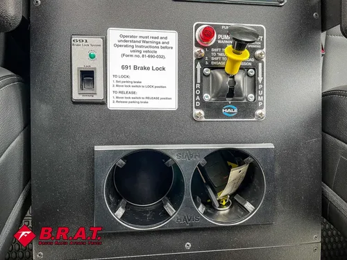 Dual cup holder panel with power outlets and small placard.
