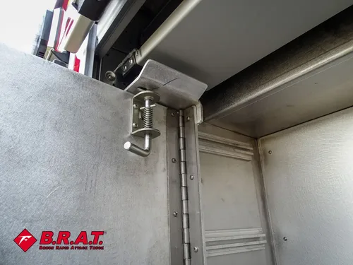 Compartment interior corner close-up with hinge and smooth metal walls.