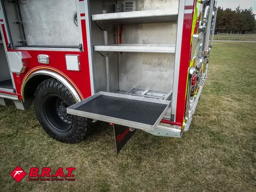 Open lower compartment with fold-down tray door beside rear wheel.