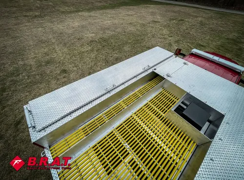 Rear deck hatch open over yellow anti-slip grate and diamond plate.