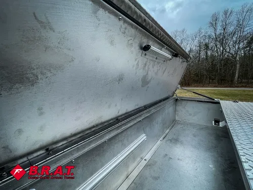 Long empty aluminum top compartment with open lid.