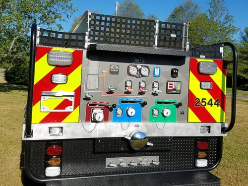 Exterior view of small fire truck showing cab, body compartments, and wheel/tire area.