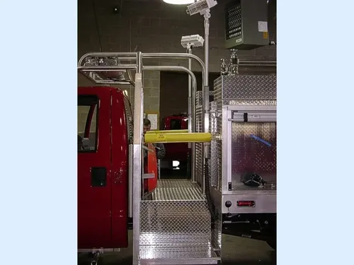Exterior view of small fire truck showing cab, body compartments, and wheel/tire area.