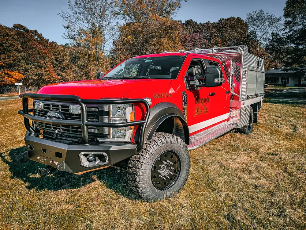Front-left three-quarter exterior view of red brush truck with utility body.