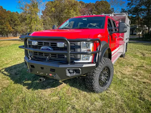 Low front-left angle emphasizing grille guard and lifted stance.