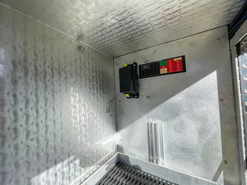 Compartment wall close-up with mounted control/charger unit.