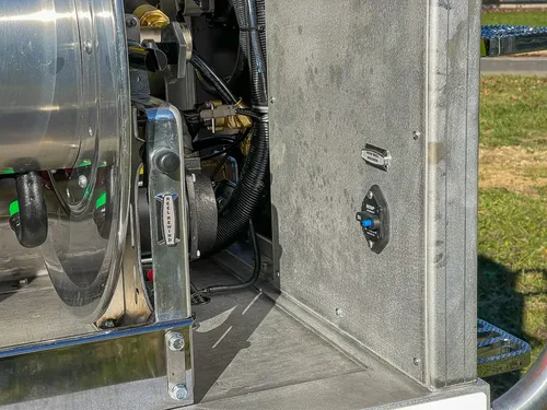 Hose reel side close-up with drive mechanism and fittings.