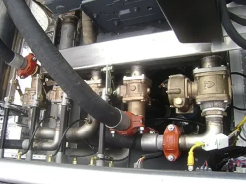 Exterior view of small fire truck showing cab, body compartments, and wheel/tire area.