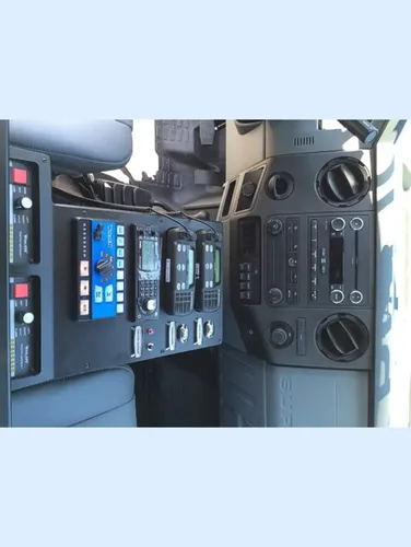 Exterior view of small fire truck showing cab, body compartments, and wheel/tire area.